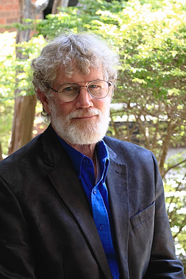 Greg Lotz wearing a navy jacket and blue shirt